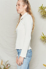 Natural long sleeve top has fitted body and sleeves with collar and button placket.