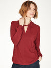 Ruby Red top with twist neck slit detail and long cuffed sleeves.