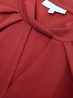 Close up on Ruby Red neckline twist neck slit detail.