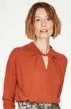 Spiced Orange top with twist neck slit detail and long cuffed sleeves.