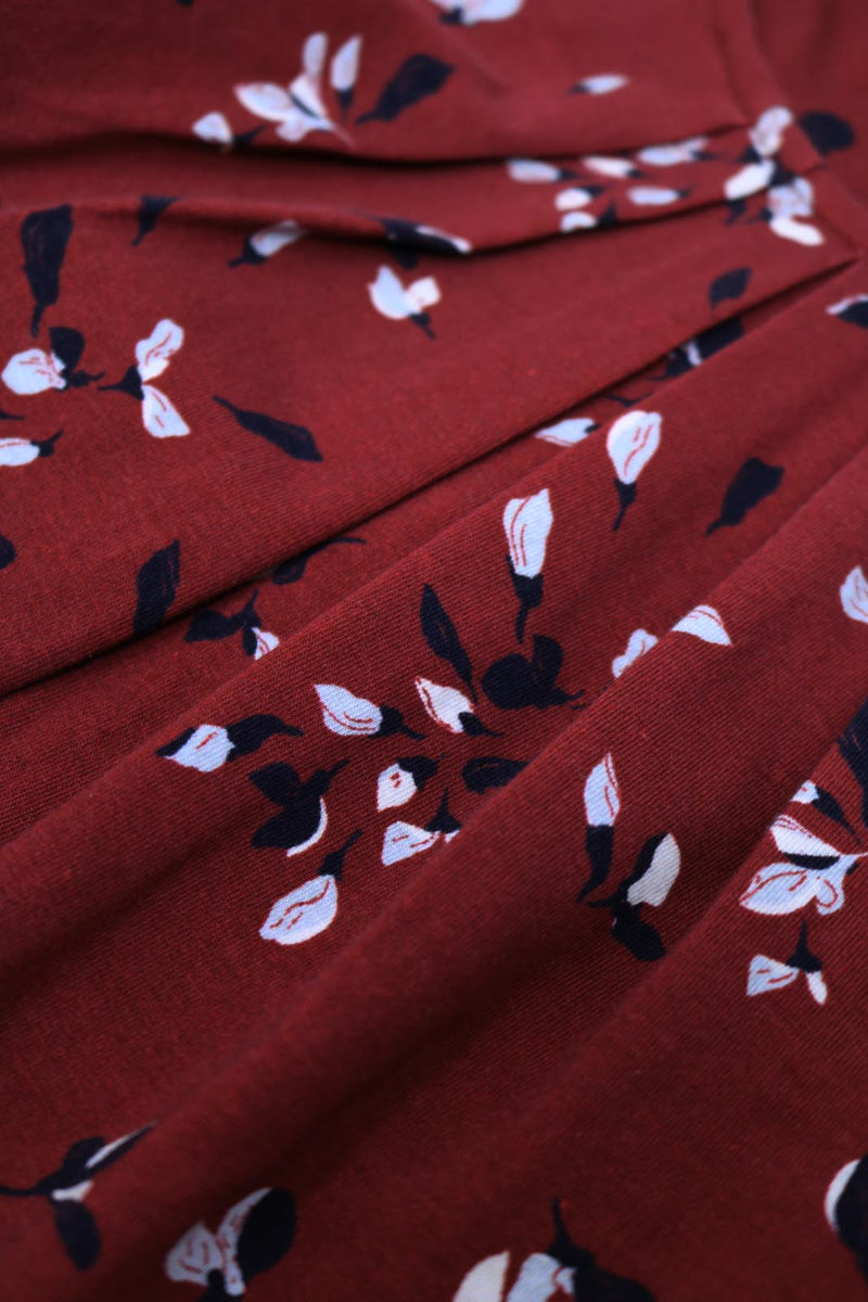 Close up on Ruby Red hand painted floral print and pleat detail.